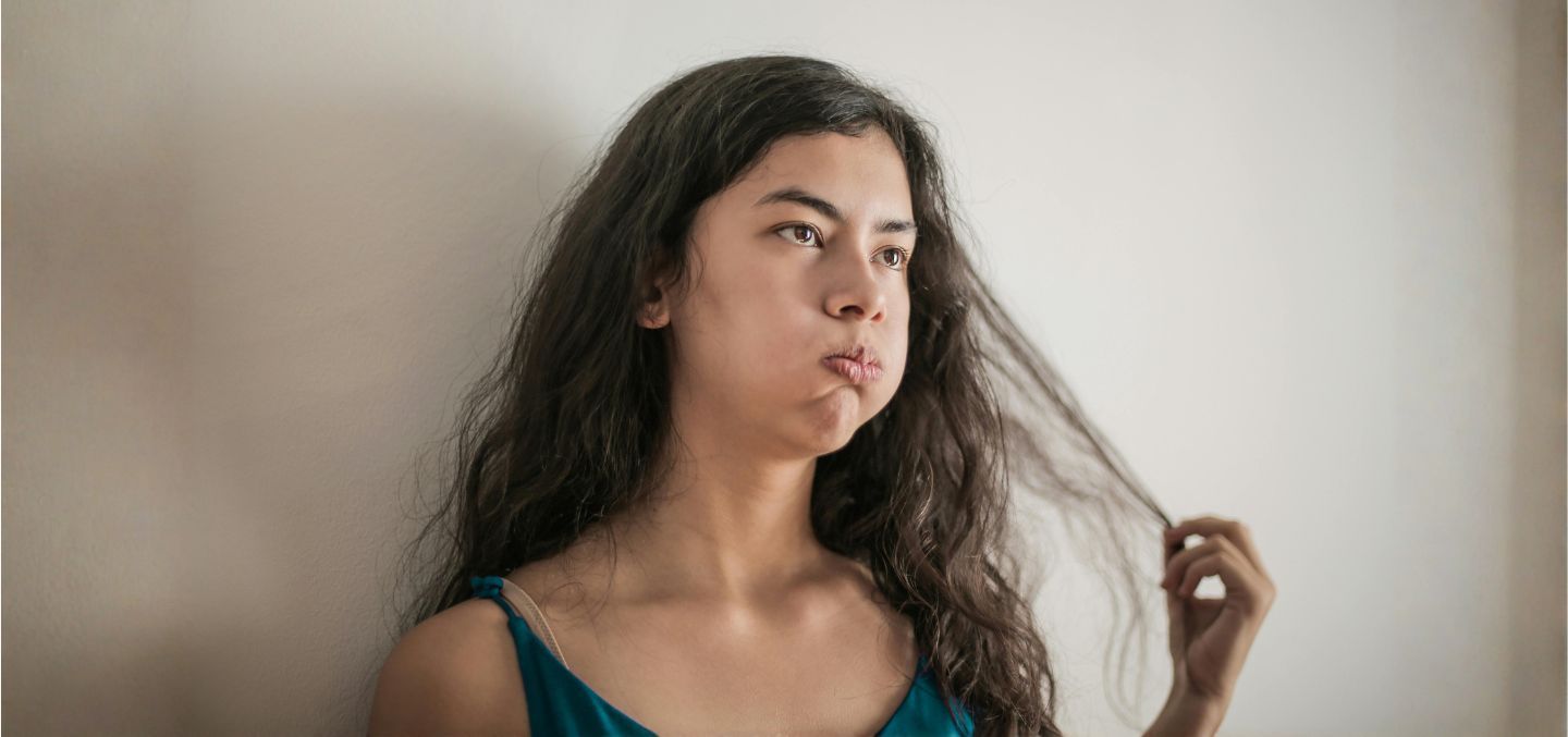 Woman looking bored and confused and playing with her hair
