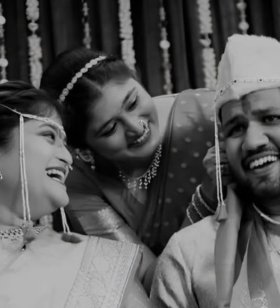 Woman standing between her sister and brother in law during their wedding.